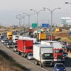 Des camions et des voitures roulent sur une autoroute. 