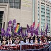Des personnes manifestent devant un immeuble en tenant des photos de femmes victimes de féminicides en Turquie.