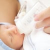 Un bébé prématuré boit du lait au biberon