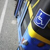 Gros plan sur une vignette posée sur un autobus indiquant que le véhicule est accessible aux personnes handicapées.