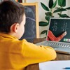 Un enfant devant un écran d'ordinateur, dans un cours de mathématique à distance.