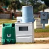 Photo de poubelles sur la rue avec une cuisinière prête à être jetée.
