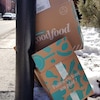 En bordure d'une rue, des boîtes de carton de l'entreprise Goodfood, qui livre des repas prêts à cuisiner. 