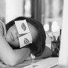 Une jeune femme a collé des cartons autocollants sur lesquels elle a dessiné des yeux, pour faire croire qu'elle est éveillée. Elle fait plutôt une sieste au bureau.