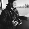 Souriant, Zacharry-David Dufour se trouve sur un bateau et tient un appareil photo dans ses mains.