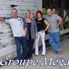 Photo du groupe Méga avec les quatre musiciens debout qui s'appuient sur un mur. Il y a un titre en blanc où l'on peut lire le nom du groupe en bas de l'image.