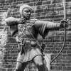 Une statue de Robin des bois qui arme son arc.
