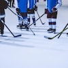Les patins et les bâtons de jeunes hockeyeurs sur une patinoire.