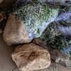 Une oeuvre imprimée sur toile et déposée sur des roches.