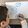 Un jeune garçon dessine un coronavirus.