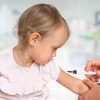 Une fillette se fait vacciner sur le bras.