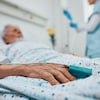 Une personne âgée couchée dans un lit d'hôpital.