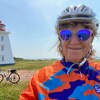 Linda Gallant devant un vélo et un phare. 