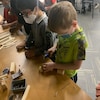 Des enfants font du travail du bois. 