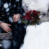 Plan rapproché d'un couple de mariés main dans la main assis sur un banc de parc un jour d'hiver.  