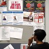 Une dame regarde un tableau d'affichage sur lequel des emplois sont proposés