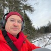 Claude Schryer, dehors en forêt, l'hiver. Il porte des écouteurs.
