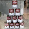 Une pyramide de boîtes de conserve dans une vitrine qui arborent des étiquettes mêlant les identités visuelles des soupes Campbell’s avec les cigarettes Marlboro