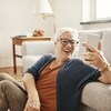 Une femme âgée prend une photo d'elle pendant qu'elle est dans son salon.