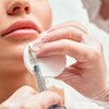 Une personne se fait injecter du Botox sur la lèvre inférieure de la bouche.