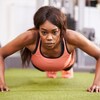 Une femme fait des pompes dans une salle d'entraînement physique.