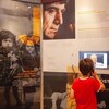 Un jeune garçon visite l'exposition « Ensemble contre le génocide ».