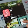 Un aperçu de l'application Airbnb sur une tablette où on voit le logo et une photo de piscine. 