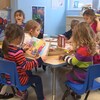 Des enfants lisent et font des casse-têtes autour d'une table.