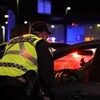 Un policier portant un gilet jaune de sécurité interpelle un automobiliste pour alcool au volant.