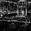 En 1980, dans le chœur de l'église Saint-Jean-Baptiste de Montréal, vue d'ensemble (en plongée) de l'Orchestre symphonique de Montréal et son chœur, et du public.