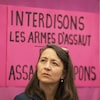 Gros plan de Nathalie Provost devant une pancarte sur laquelle on peut lire : « interdisons les armes d'assaut ».