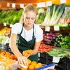 Une adolescente place des clémentines dans une fruiterie. 