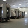Trois wagons  de trains dans un entrepôt.