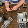 Une personne répare un aspirateur avec de nombreux outils. 