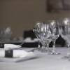 Des verres et des assiettes sur une table avec une nappe blanche.