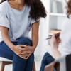 Plan cadré sans montrer les visages de deux femmes assisent l'une en face de l'autre. 
