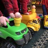 Trois enfants non identifiés d'âge préscolaire jouent ensemble avec des camions-jouets dans un service de garde.