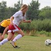 Une fille court sur un terrain de soccer.