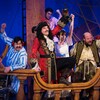 Des comédien déguisés en pirates sur une scène qui ressemble à un bateau.