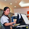 Une adolescente d'origine asiatique travaille dans une épicerie.