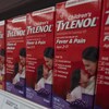 Gros plan de boîtes de Tylenol pour enfants à saveur de raisin sur la tablette d'une pharmacie. 