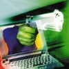 Composition numérique d'une main tenant un pistolet émergeant d'un écran d'ordinateur portable. 