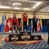 Trois athlètes féminines d'haltérophilie sur un podium.