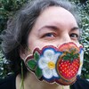 L'artiste métisse Nathalie Bertin porte sur son visage le masque qu'elle a conçu en broderie perlée qui signifie « Dis ta vérité. Toujours. » . On y voit une fraise géante et deux fleurs blanches de chaque côté.