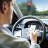 Un homme échange des textos tout en conduisant.