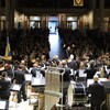 Un orchestre devant une foule de spectateurs. 