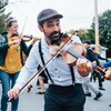 Des musiciens avec des violons qui jouent de la musique dans une rue.