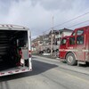 Des camions de pompier devant un immeuble à logements.
