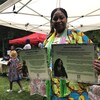 Mariame Cissé tient dans ses mains deux plaques à l'effigie de bâtisseurs issus des communautés noires.
