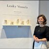Maryon Bouchard devant l'affiche de son exposition Leaky Vessels.